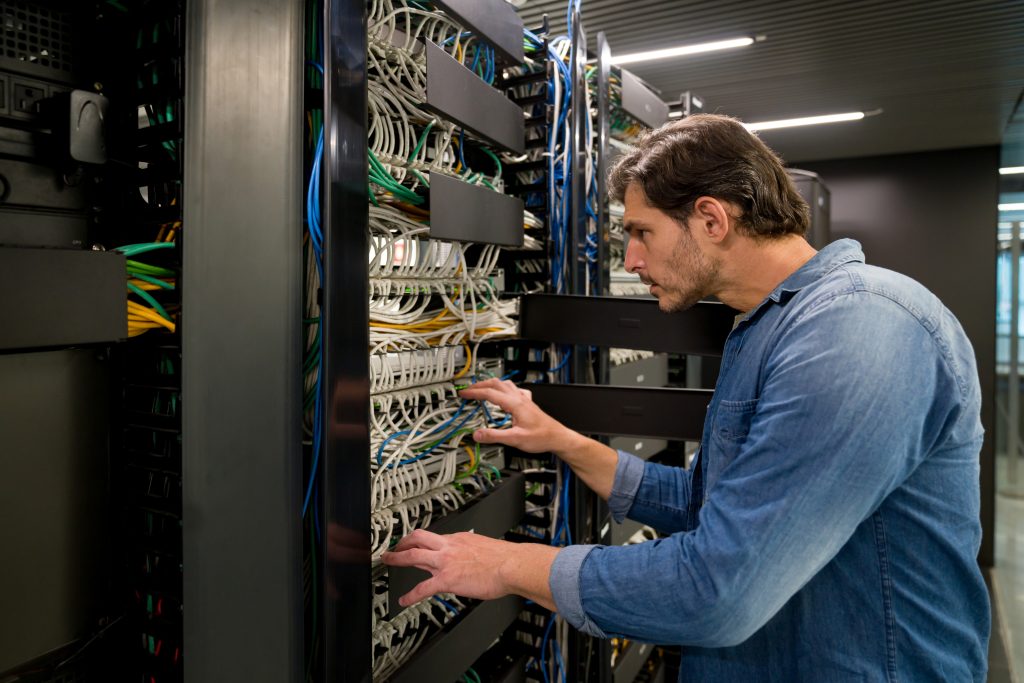 Network cabling technician installing network cables for office